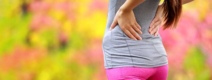 Woman holding sore back